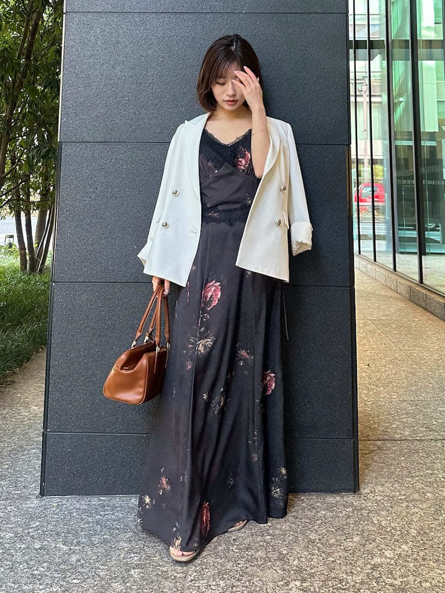 ブラック系のキャミソール、ホワイト系のテーラードジャケット、ブラック系のワンピースを着用したレディースの春コーディネートの3枚目の写真