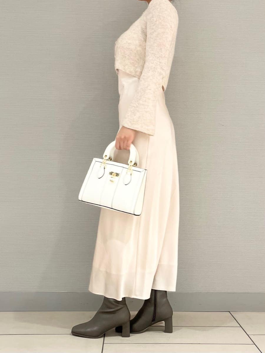 ピンク系のワンピース、ホワイト系のハンドバッグを着用したレディースの冬コーディネートの2枚目の写真