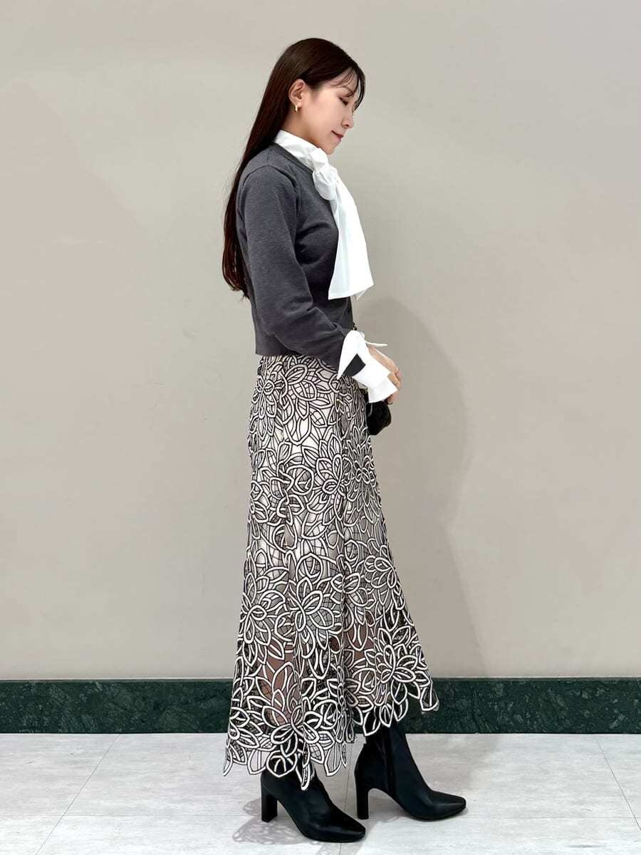 グレー系のニット/セーター、その他のスカート、ブラック系のブーツを着用したレディースの秋コーディネートの4枚目の写真