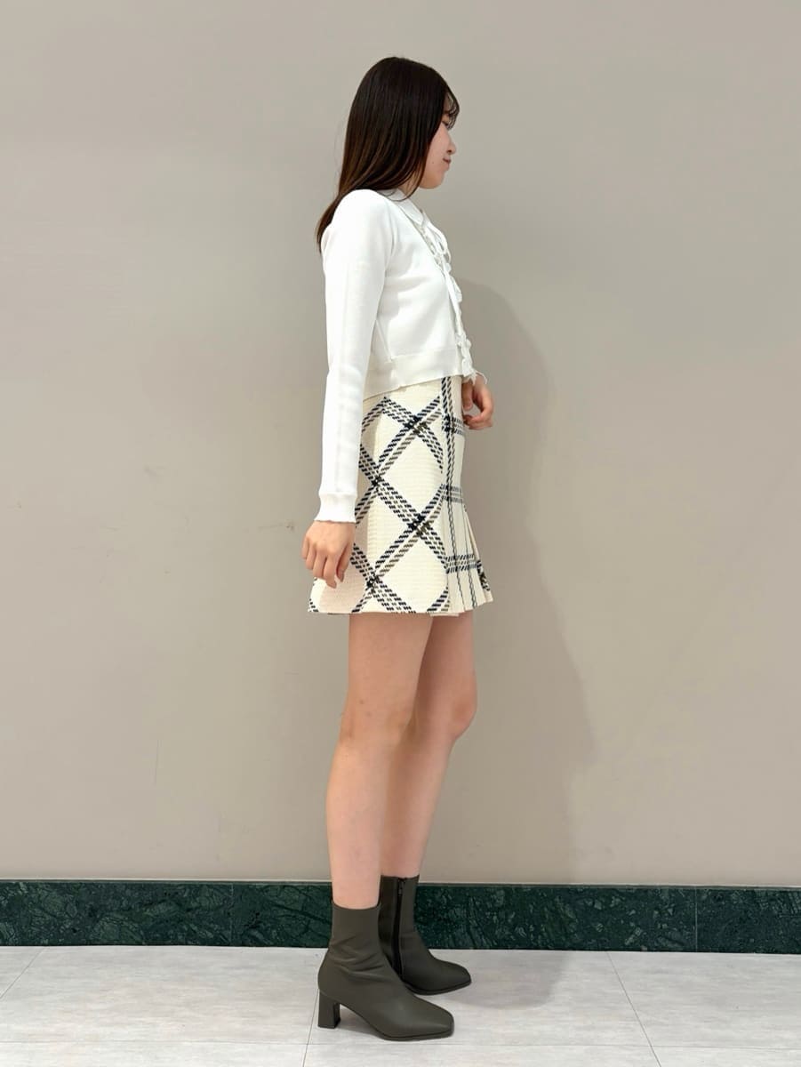 ホワイト系のスカート、ブラック系のショルダーバッグ、ホワイト系のカーディガン/ボレロを着用したレディースの冬コーディネートの4枚目の写真