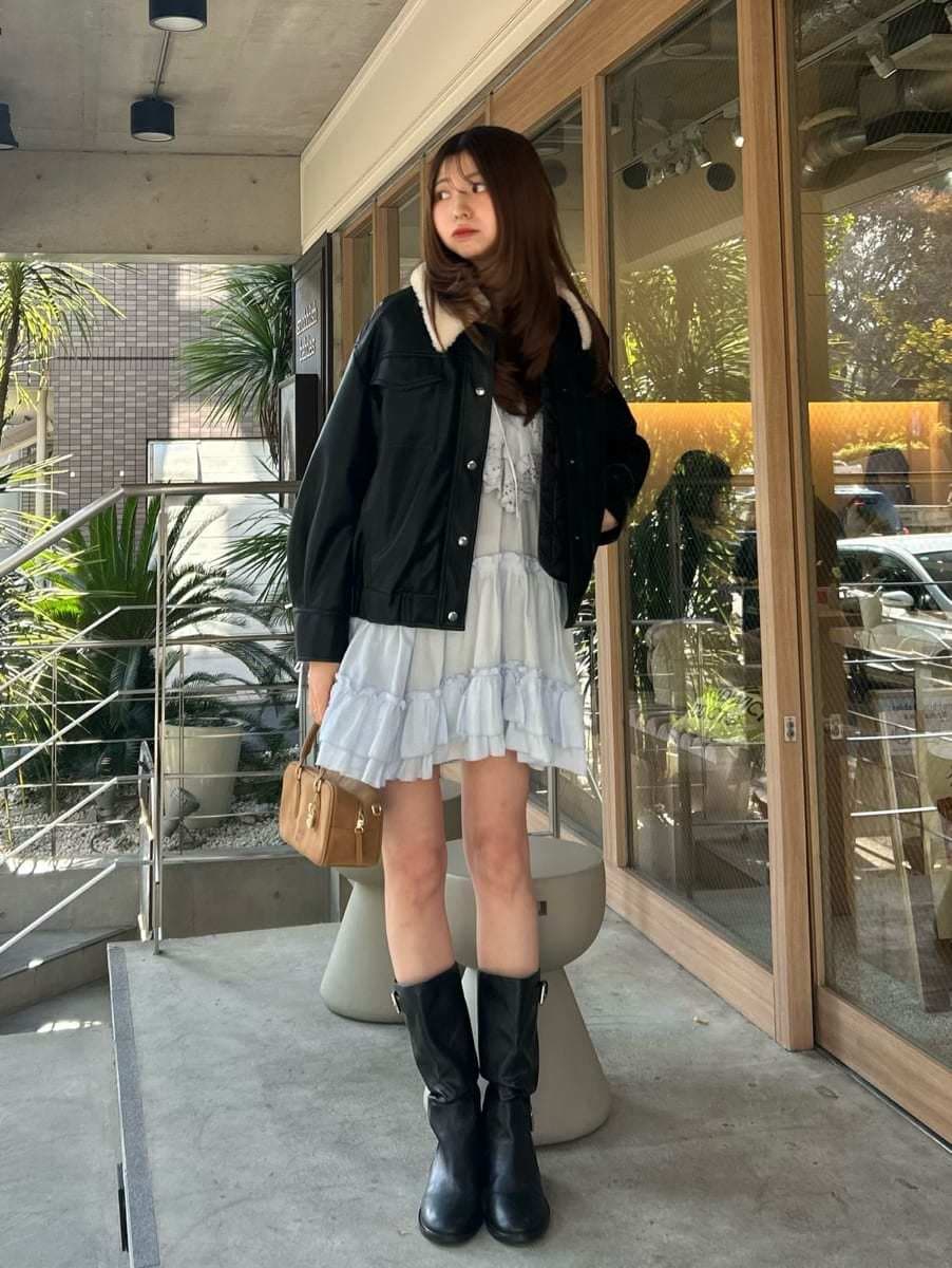 イエロー系のボストンバッグ、ブラック系のブルゾン、ブルー系のその他トップスを着用したレディースの冬コーディネートの4枚目の写真