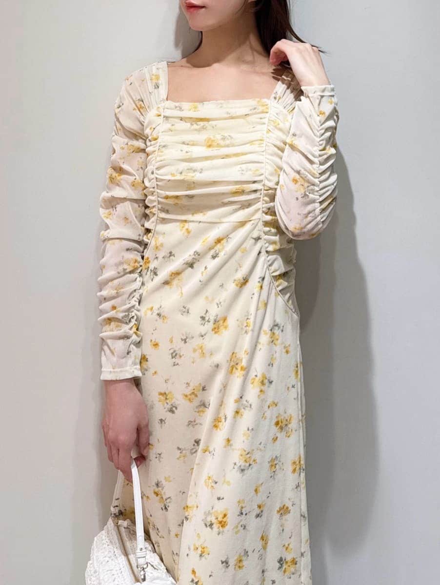 ブラウン系のブーツ、ホワイト系のブルゾン、イエロー系のワンピースを着用したレディースの冬コーディネートの5枚目の写真