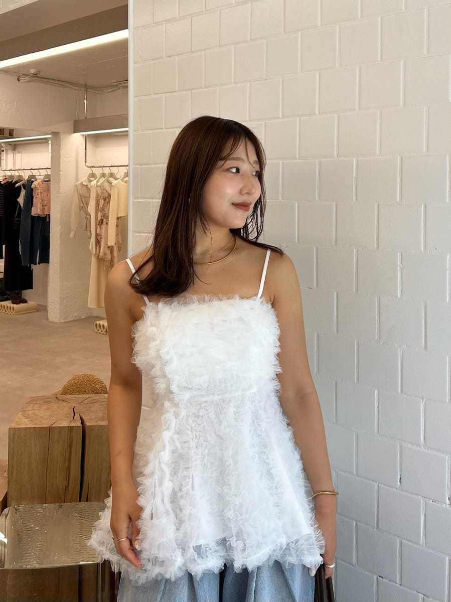 ブラック系のサンダル、ブルー系のデニムパンツ、ブラウン系のトートバッグを着用したレディースの夏コーディネートの8枚目の写真
