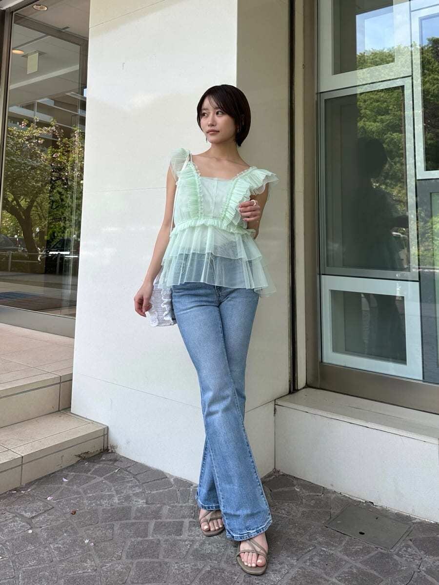 グリーン系のシャツ/ブラウス、ブルー系のデニムパンツ、ホワイト系のショルダーバッグを着用したレディースの春コーディネートの2枚目の写真