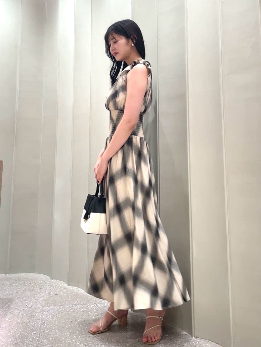 その他のハンドバッグ、ベージュ系のワンピース、その他のサンダルを着用したレディースの夏コーディネートの7枚目の写真