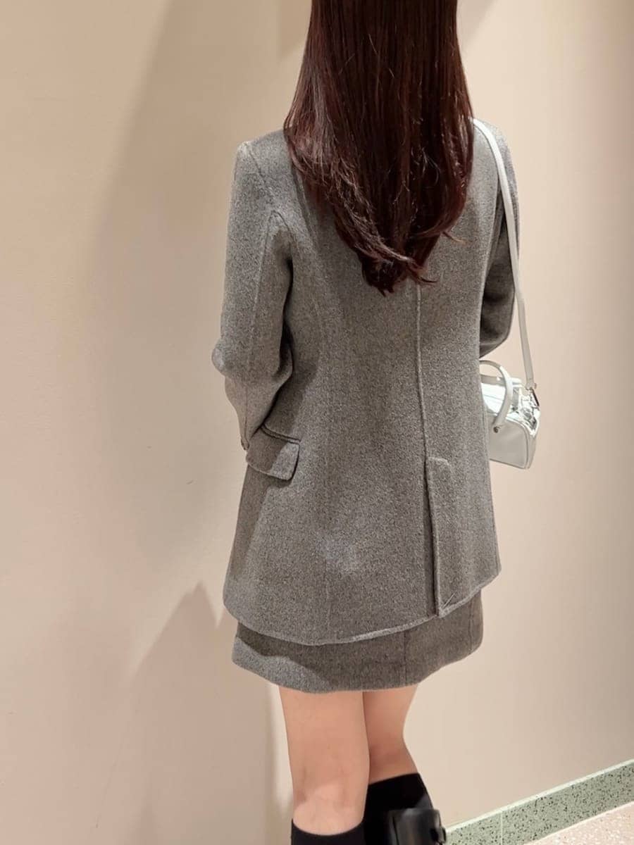 ブラック系のブーツ、グレー系のテーラードジャケット、グレー系のワンピースを着用したレディースの秋コーディネートの3枚目の写真