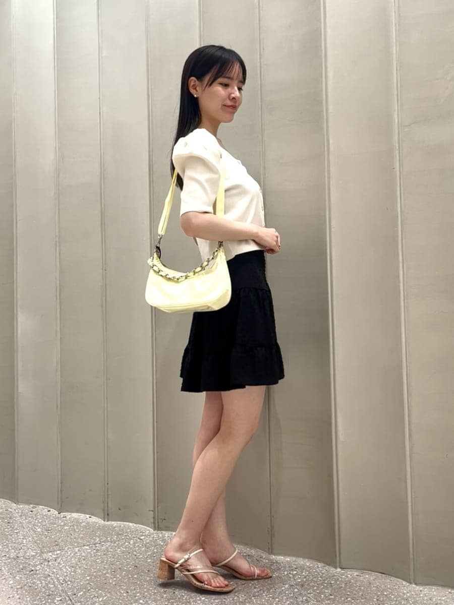 ブラック系のワンピース、ホワイト系のカーディガン/ボレロ、イエロー系のショルダーバッグを着用したレディースの夏コーディネートの3枚目の写真