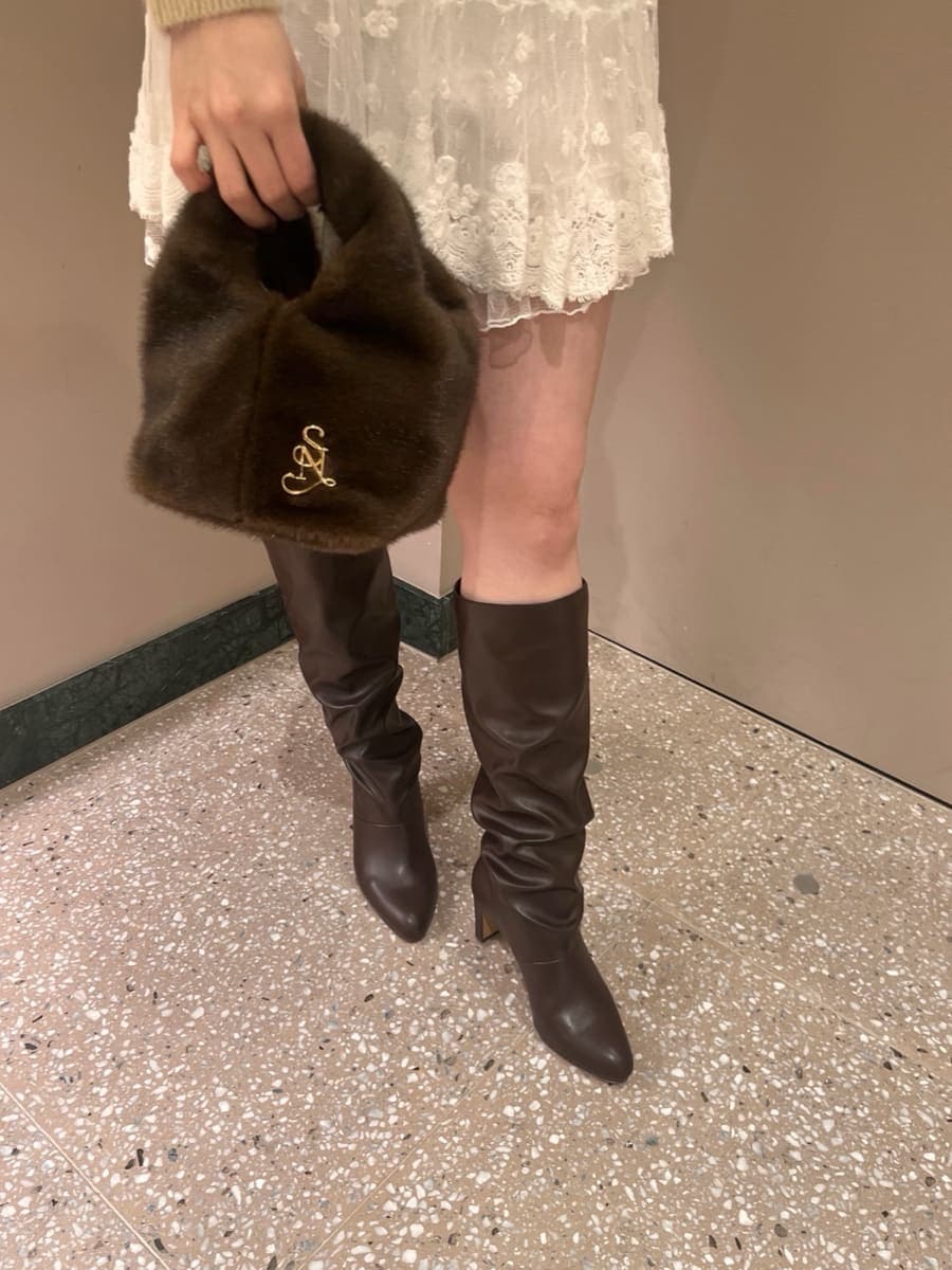 ベージュ系のニット/セーター、その他のその他パンツ、ブラウン系のハンドバッグを着用したレディースの冬コーディネートの6枚目の写真