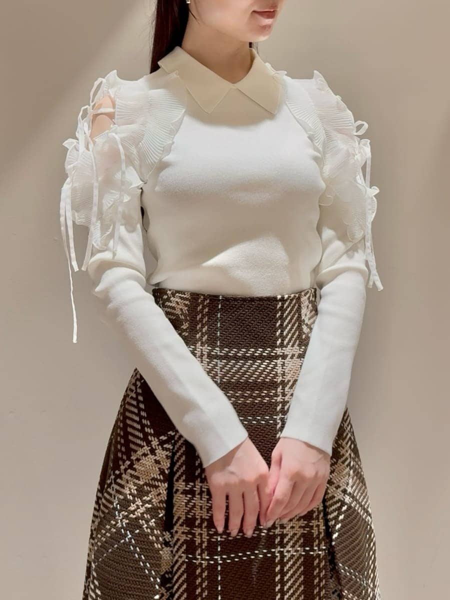 ホワイト系のニット/セーター、ブラウン系のスカート、レッド系のブーツを着用したレディースの秋コーディネートの4枚目の写真