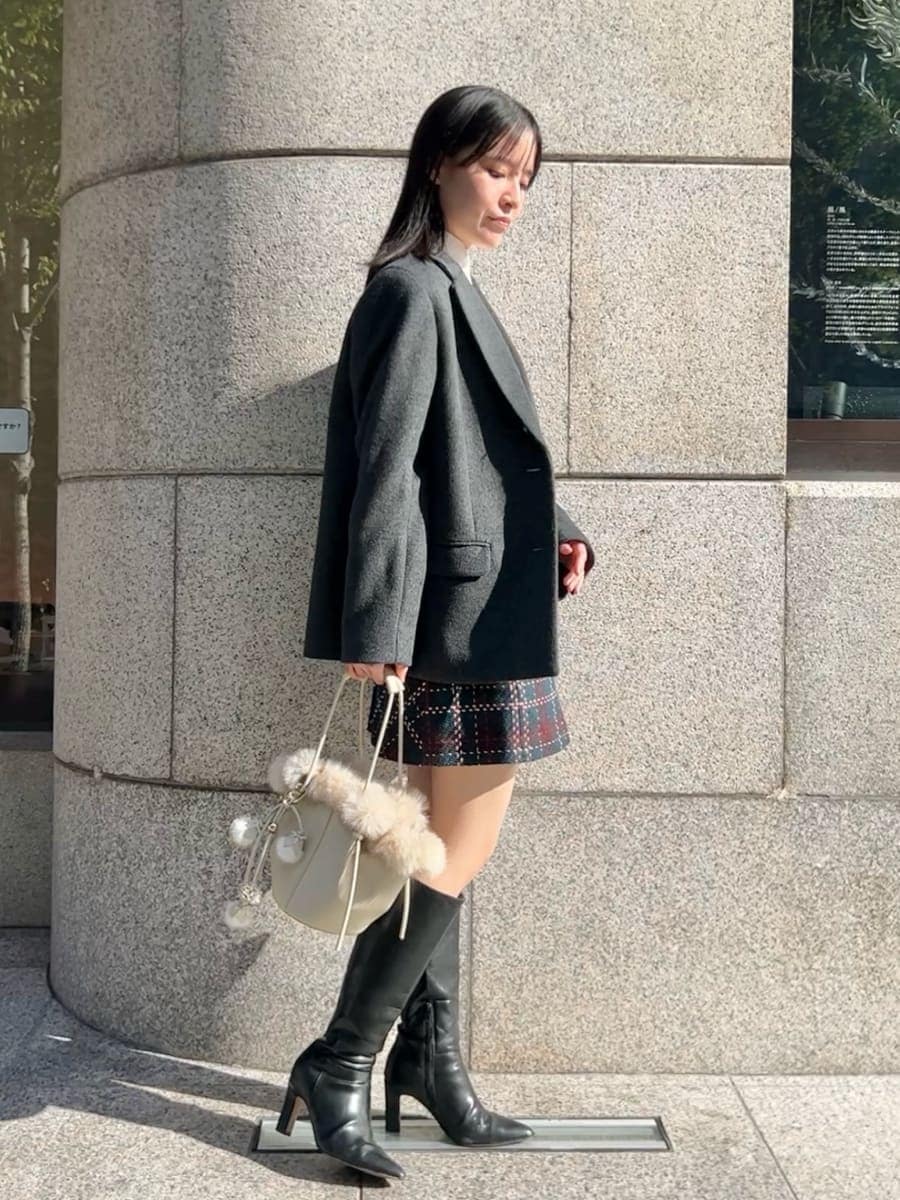 ホワイト系のニット/セーター、ブラック系のブーツ、グレー系のテーラードジャケットを着用したレディースの秋コーディネートの2枚目の写真