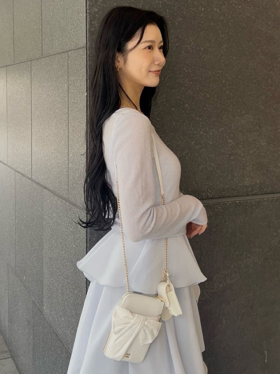 ブルー系のワンピース、その他のパンプス、ホワイト系のショルダーバッグを着用したレディースの冬コーディネートの6枚目の写真