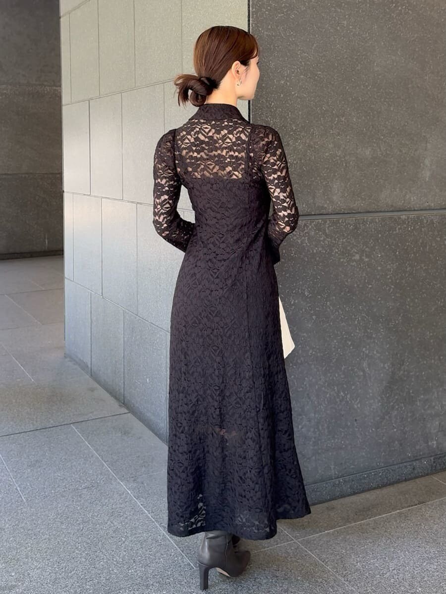 グレー系のブーツ、ブラック系のワンピース、ホワイト系のハンドバッグを着用したレディースの冬コーディネートの3枚目の写真