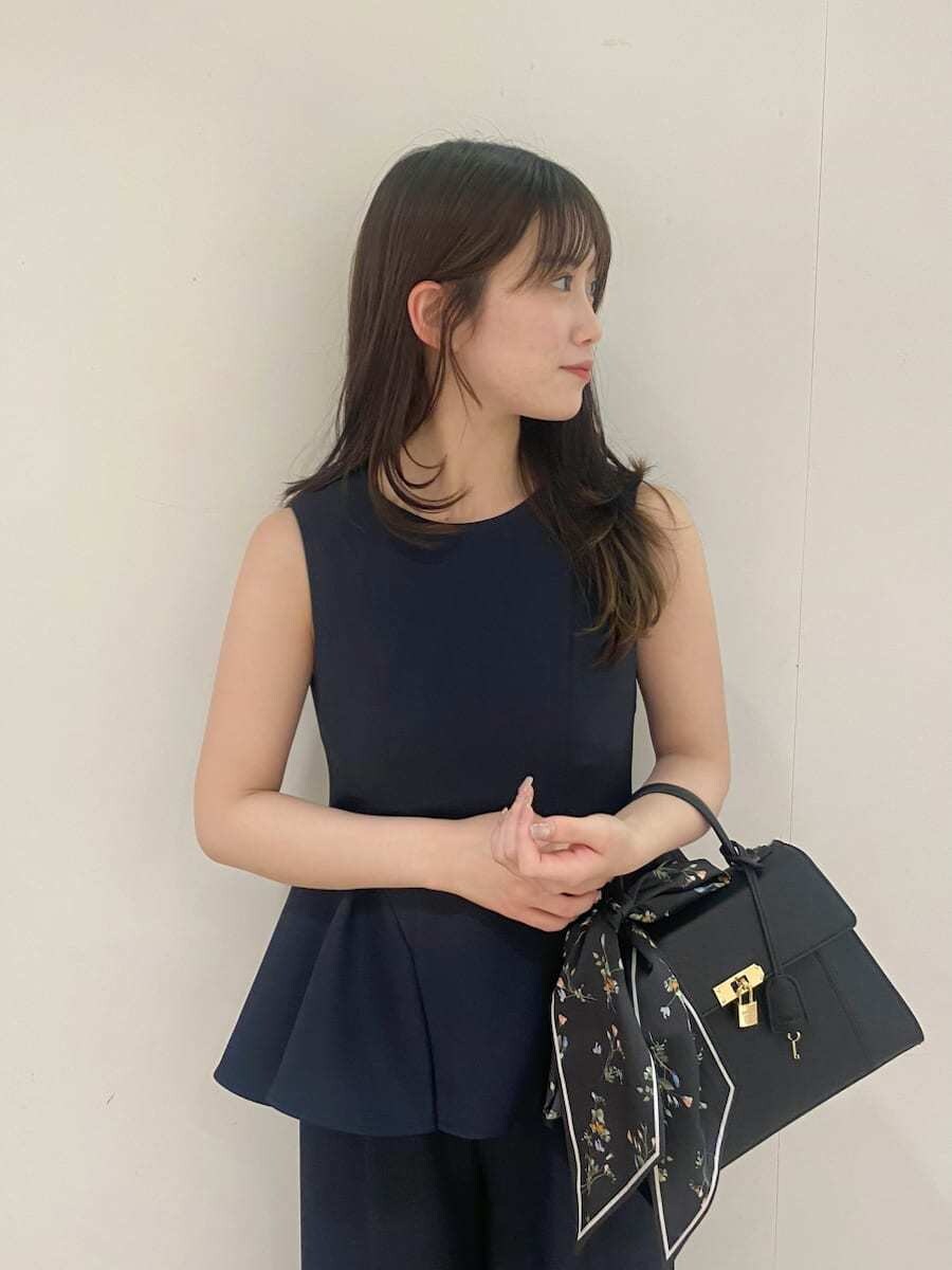 ブルー系のワンピース、ブラック系のパンプス、ブラック系のハンドバッグを着用したレディースの春コーディネートの4枚目の写真