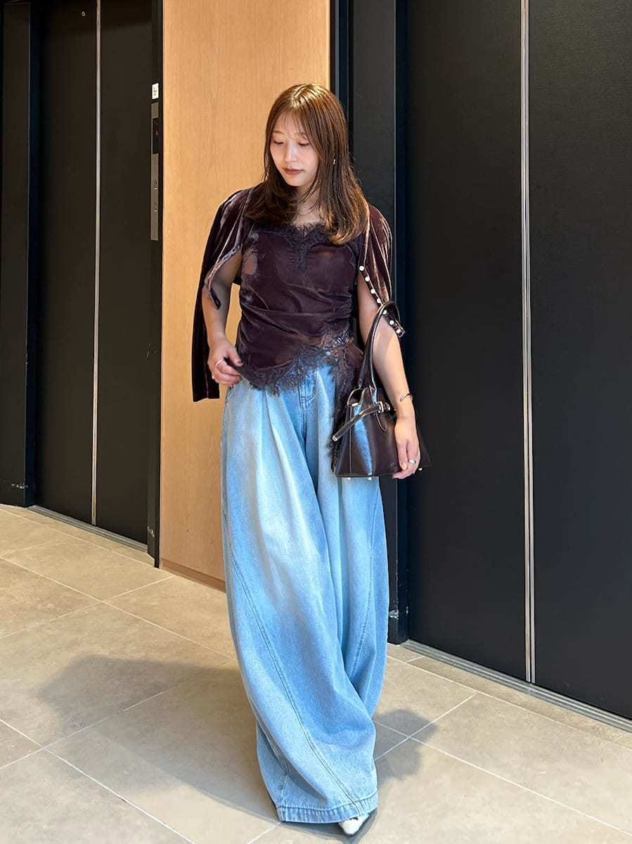 ブルー系のデニムパンツ、ブラウン系のキャミソール、ブラウン系のカーディガン/ボレロを着用したレディースの秋コーディネートの2枚目の写真