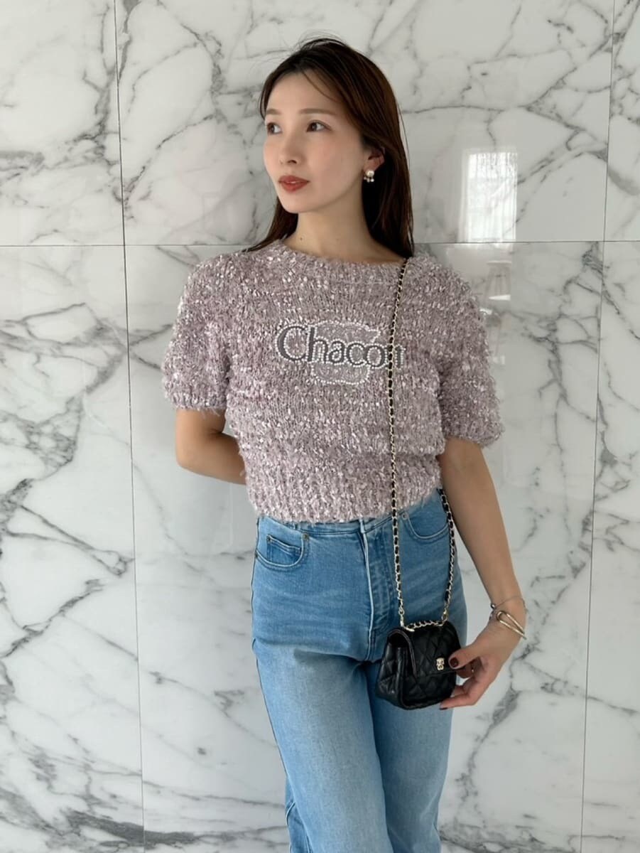 ブラウン系のニット/セーター、ブルー系のデニムパンツ、ブラック系のショルダーバッグを着用したレディースの夏コーディネートの2枚目の写真