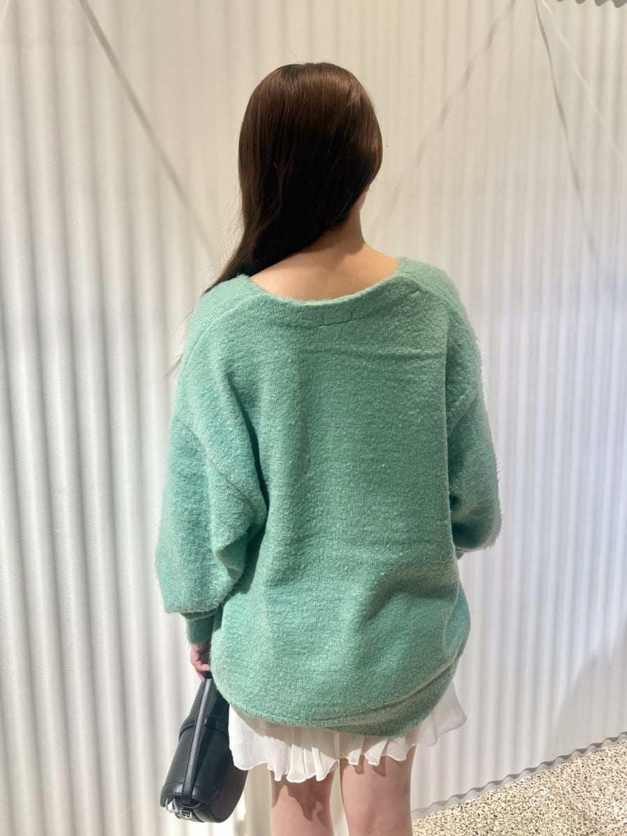 グリーン系のカーディガン/ボレロ、ホワイト系のその他パンツ、ブラック系のハンドバッグを着用したレディースの秋コーディネートの6枚目の写真