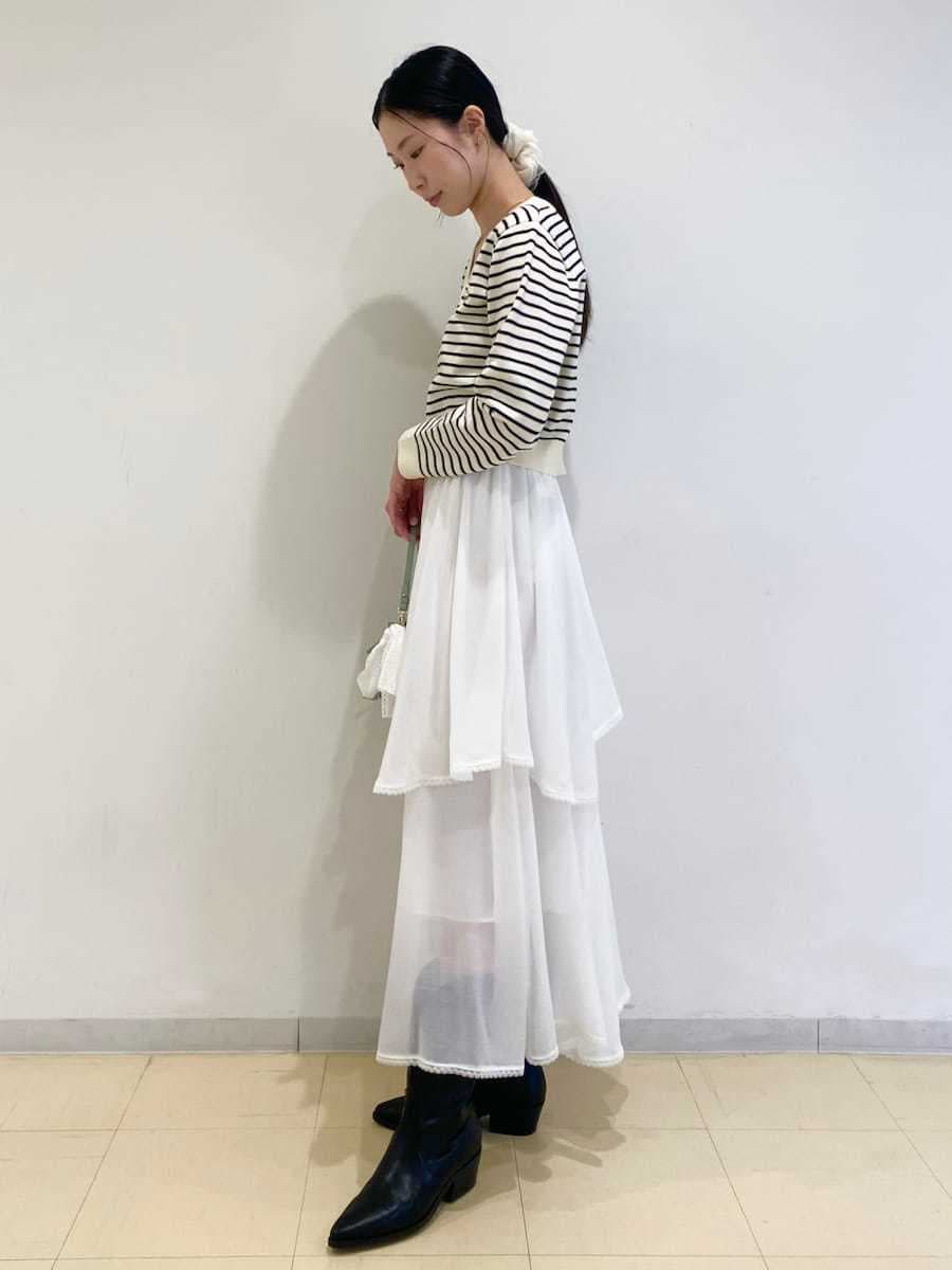 ブラック系のパンプス、ホワイト系のスカート、その他のニット/セーターを着用したレディースの冬コーディネートの3枚目の写真