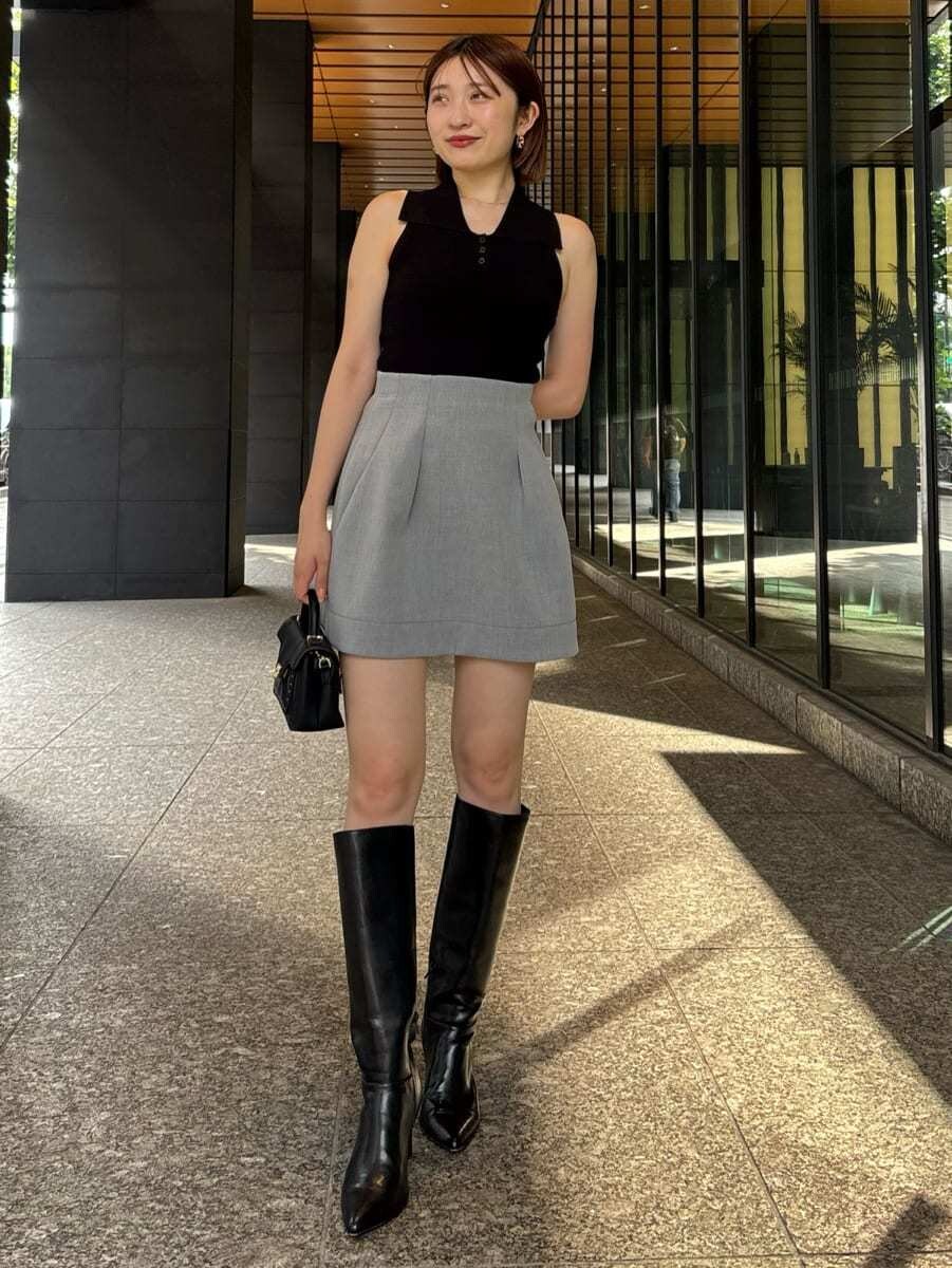 ブラック系のニット/セーター、グレー系のその他パンツ、ブラック系のブーツを着用したレディースの夏コーディネートの2枚目の写真