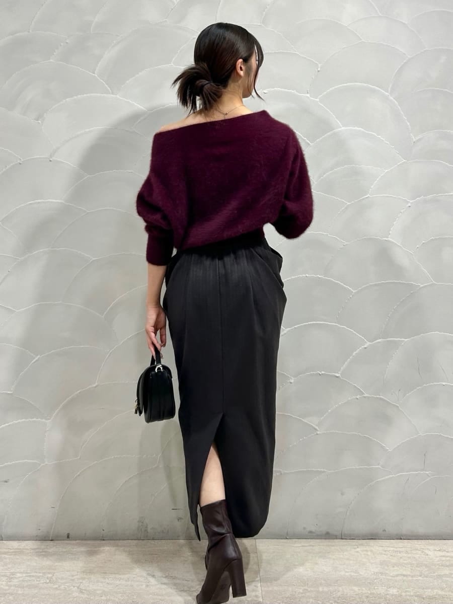 レッド系のニット/セーター、グレー系のスカート、ブラック系のハンドバッグを着用したレディースの秋コーディネートの3枚目の写真