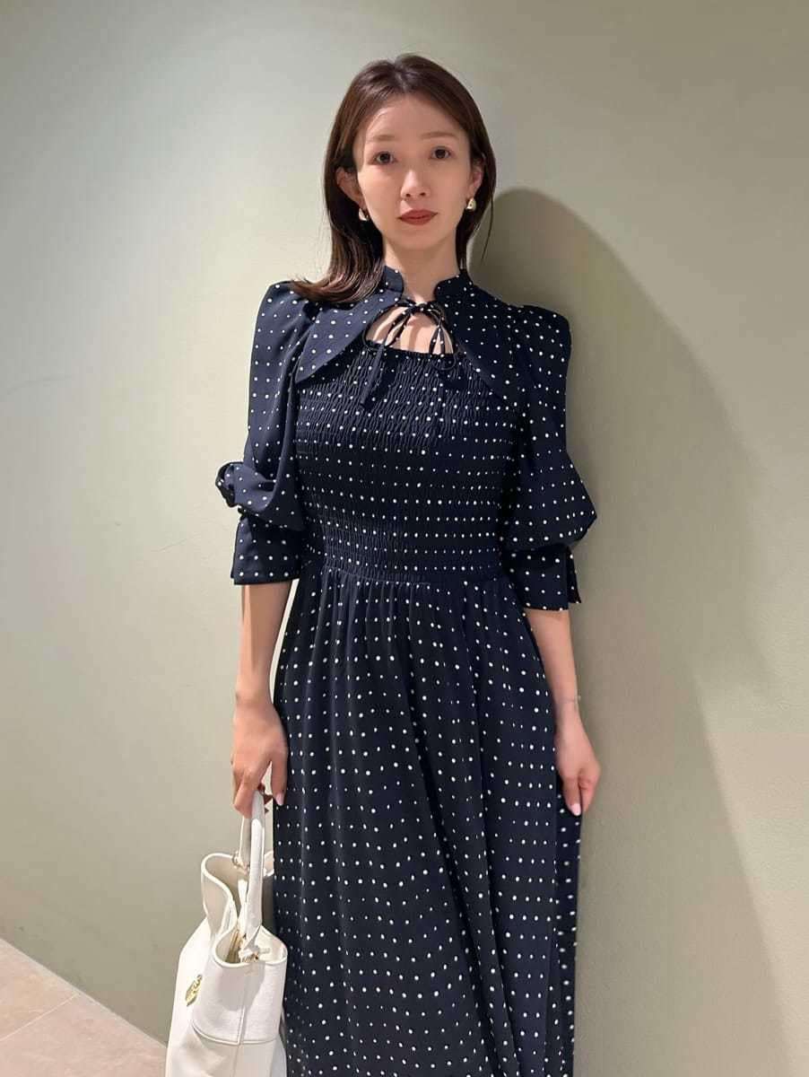 ホワイト系のハンドバッグ、ブルー系のワンピースを着用したレディースの春コーディネートの2枚目の写真