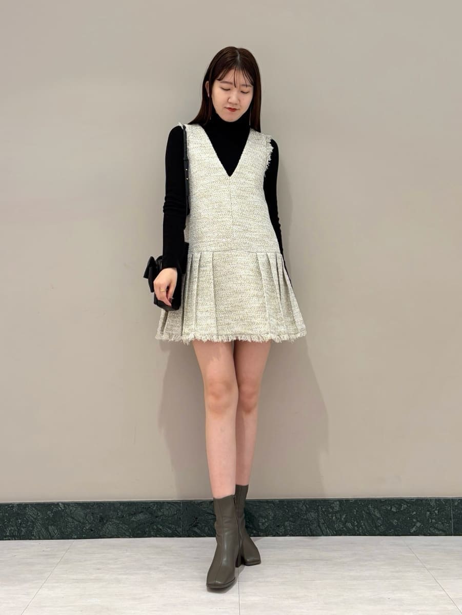 ホワイト系のワンピース、ブラック系のニット/セーター、ブラック系のショルダーバッグを着用したレディースの冬コーディネートの3枚目の写真