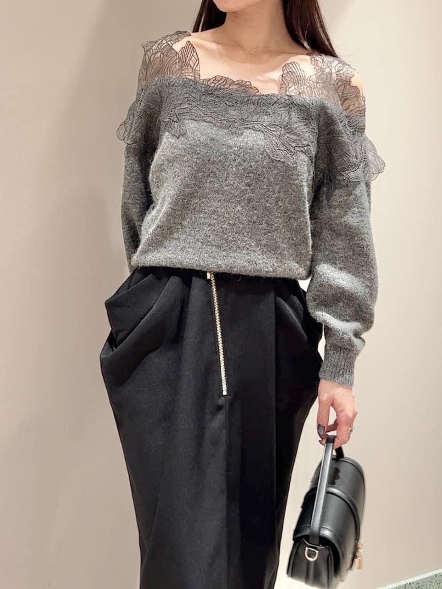 グレー系のニット/セーター、ブラック系のスカート、ブラック系のハンドバッグを着用したレディースの秋コーディネートの5枚目の写真