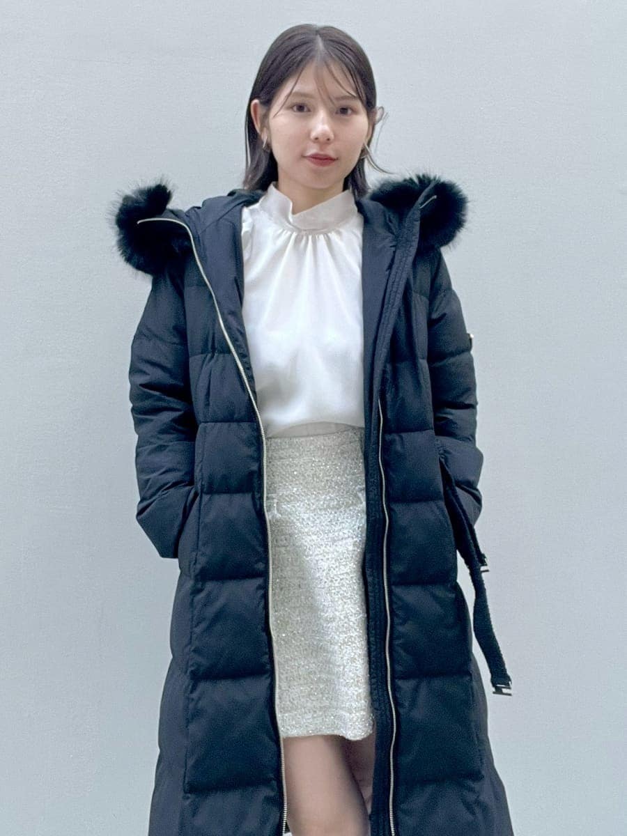 ホワイト系のスカート、ブラック系のブーツ、ブラック系のダウンジャケット/コートを着用したレディースの冬コーディネートの3枚目の写真