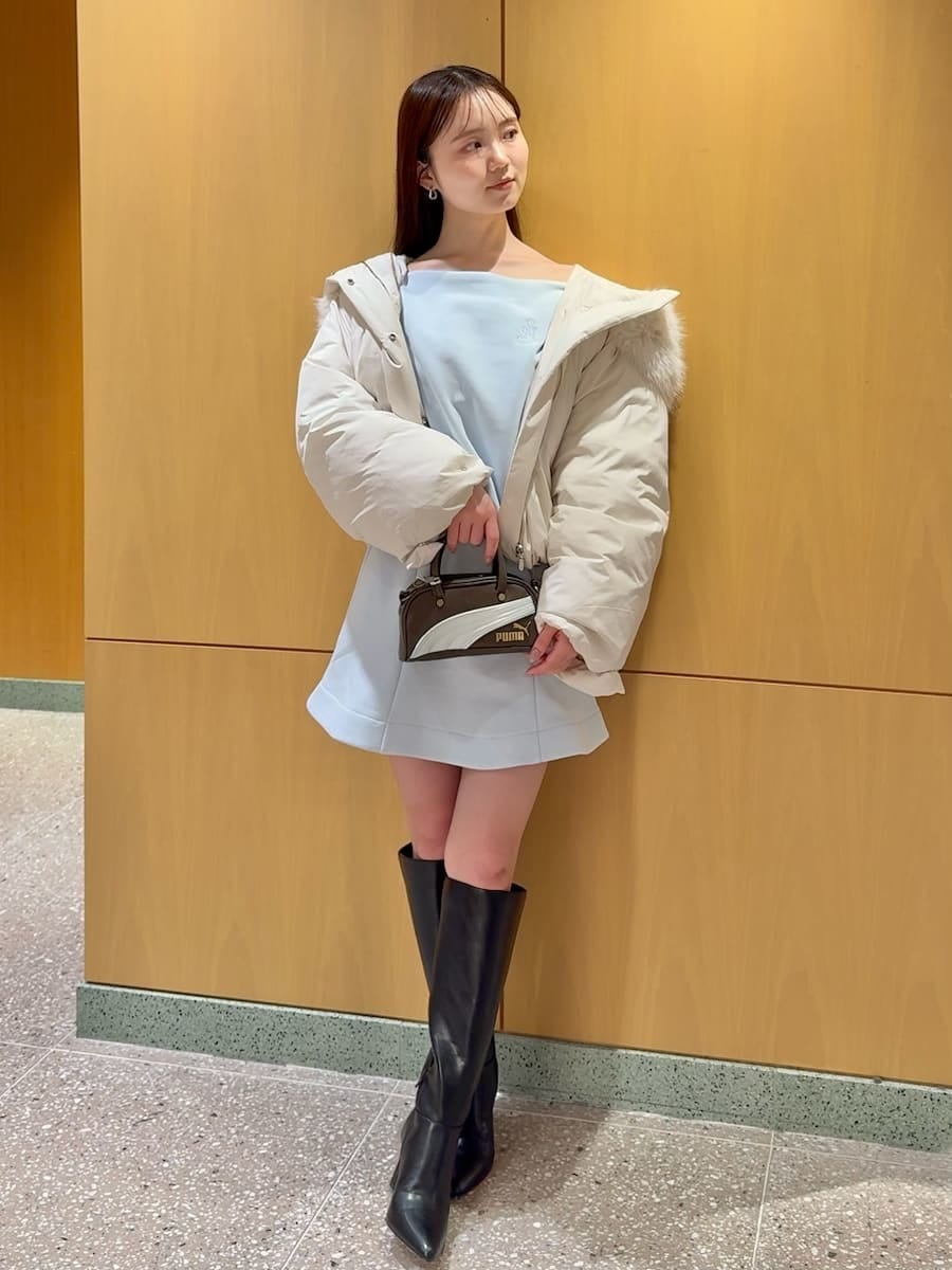 ブラック系のブーツ、ホワイト系のダウンジャケット/コート、ブルー系のワンピースを着用したレディースの冬コーディネートの2枚目の写真