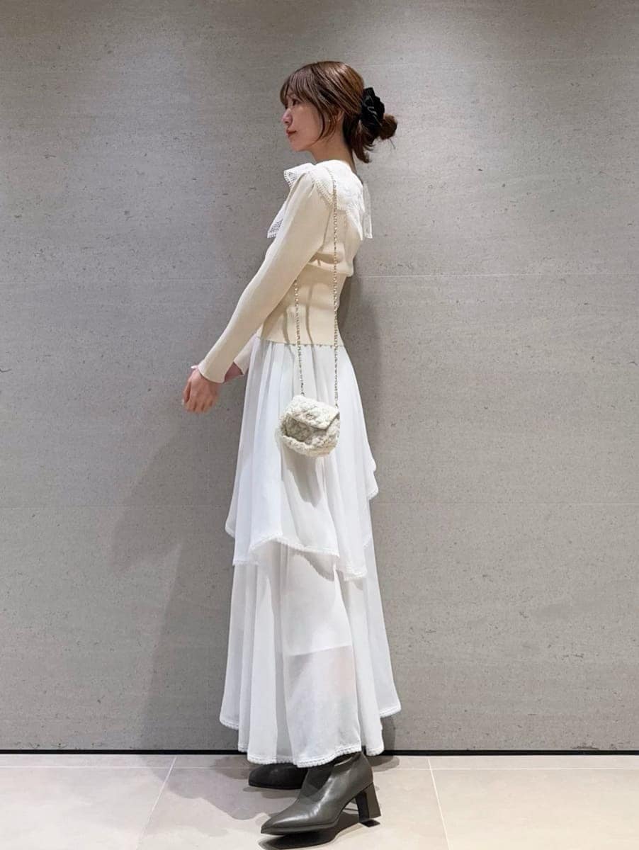 ホワイト系のショルダーバッグ、ホワイト系のスカート、ホワイト系のニット/セーターを着用したレディースの冬コーディネートの2枚目の写真