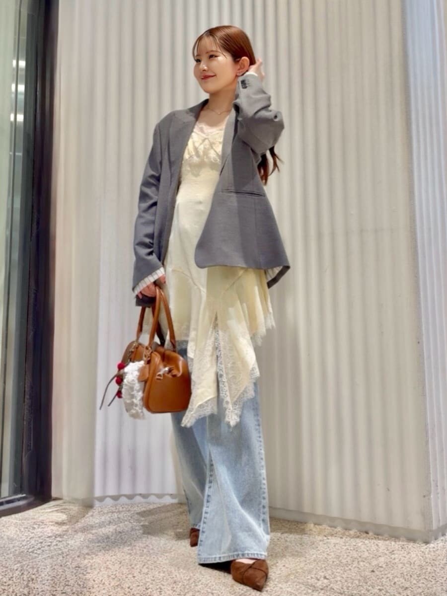 グレー系のテーラードジャケット、ブルー系のデニムパンツ、イエロー系のキャミソールを着用したレディースの春コーディネートの7枚目の写真