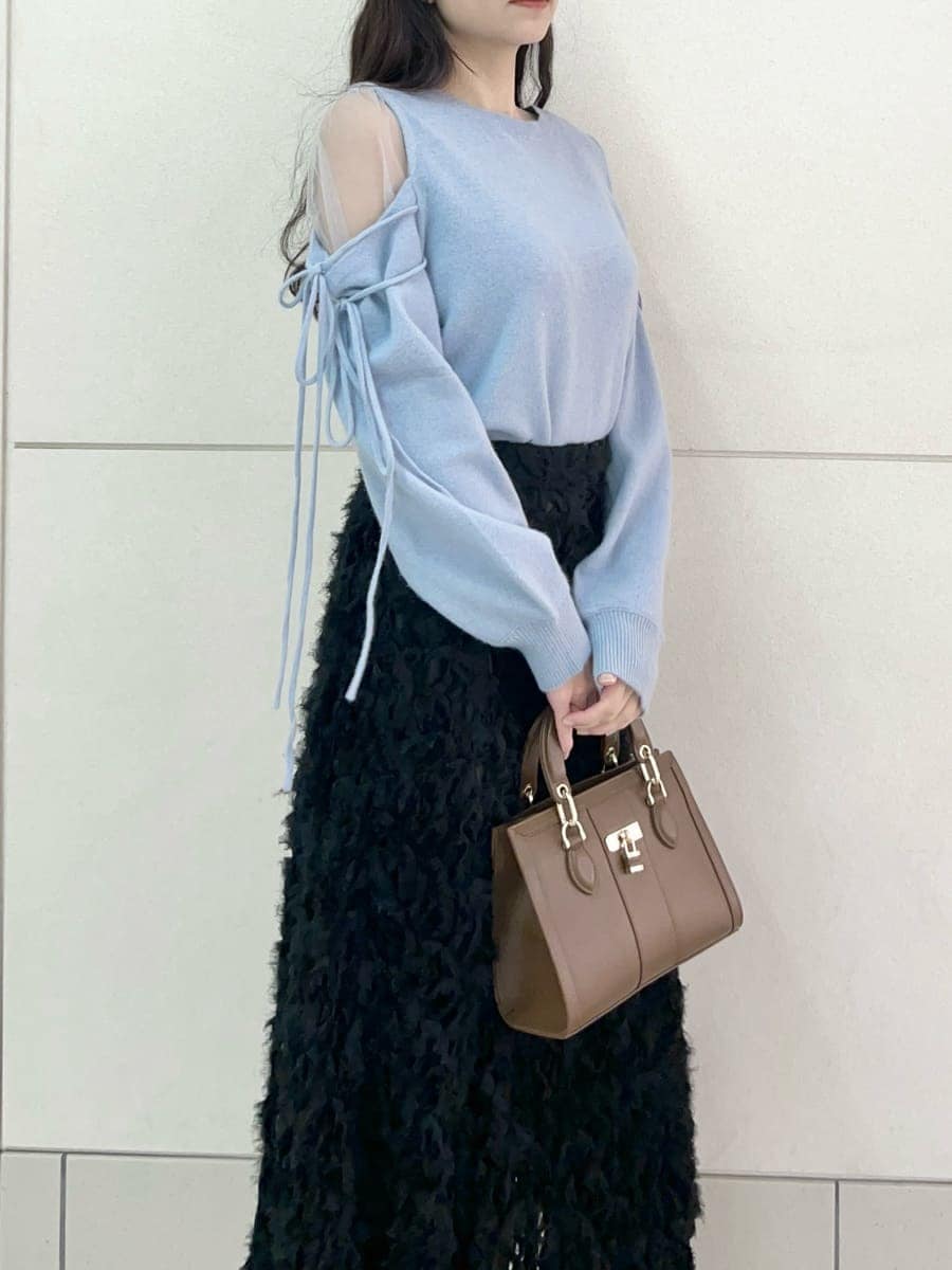 ブラック系のブーツ、ブラック系のスカート、ブルー系のニット/セーターを着用したレディースの冬コーディネートの6枚目の写真