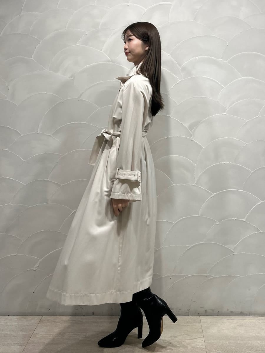 ブラック系のブーツ、ホワイト系のトレンチコート、グレー系のワンピースを着用したレディースの冬コーディネートの4枚目の写真