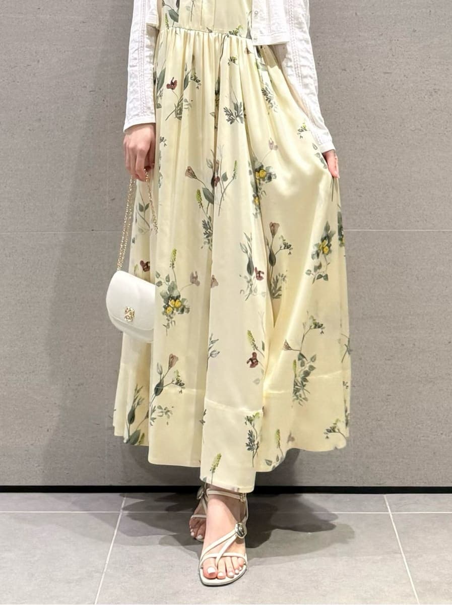 イエロー系のワンピース、ホワイト系のカーディガン/ボレロ、ホワイト系のショルダーバッグを着用したレディースの春コーディネートの5枚目の写真