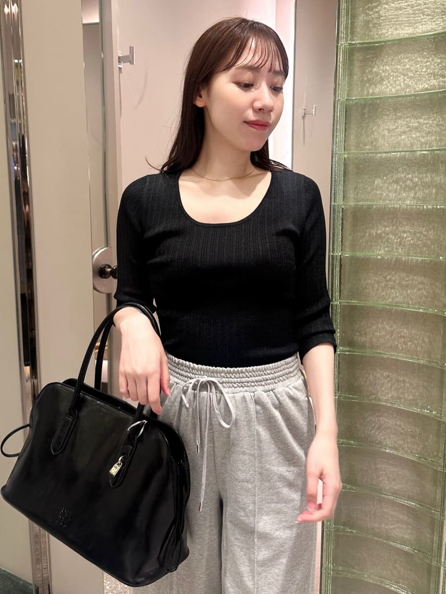 ブラック系のニット/セーター、グレー系のその他パンツ、ブラック系のハンドバッグを着用したレディースの秋コーディネートの2枚目の写真