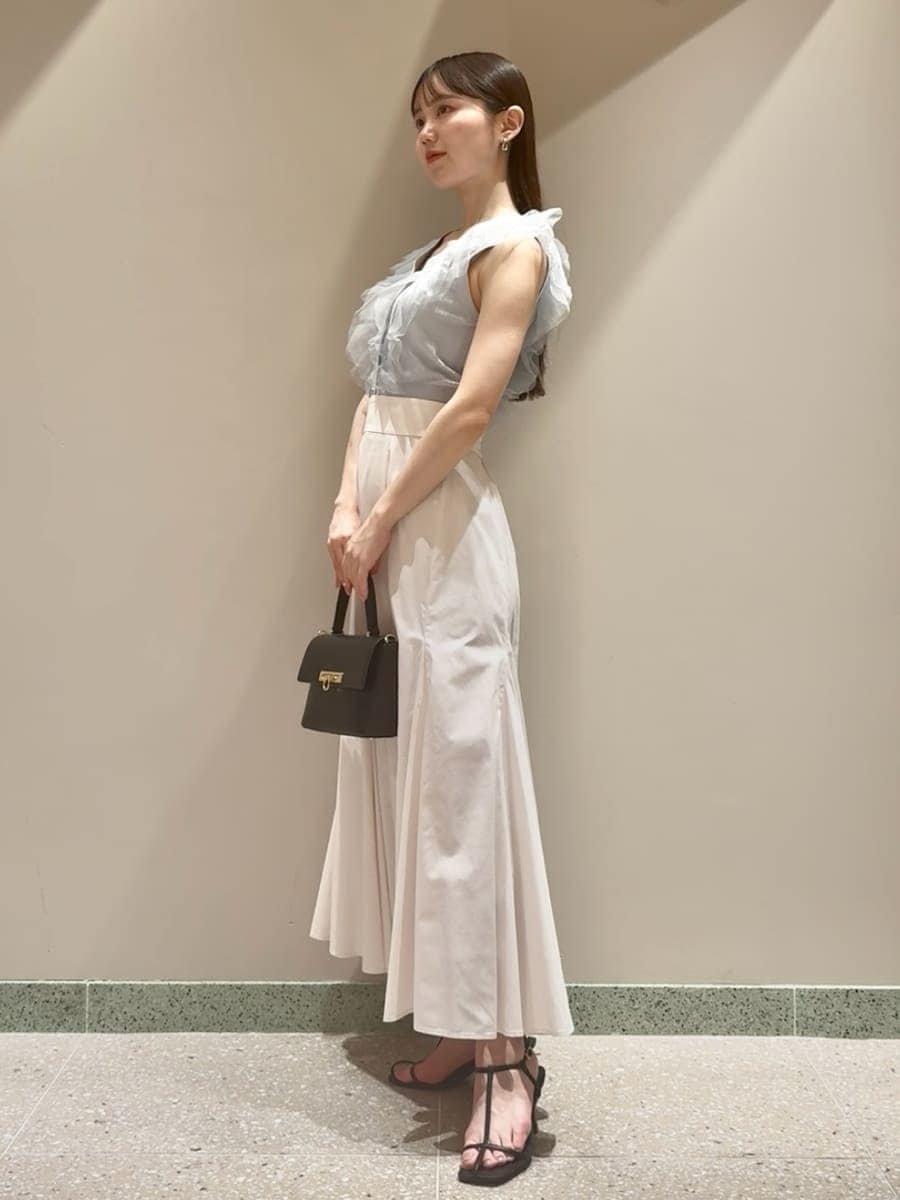 ブルー系のニット/セーター、ホワイト系のスカート、ブラック系のサンダルを着用したレディースの夏コーディネートの2枚目の写真