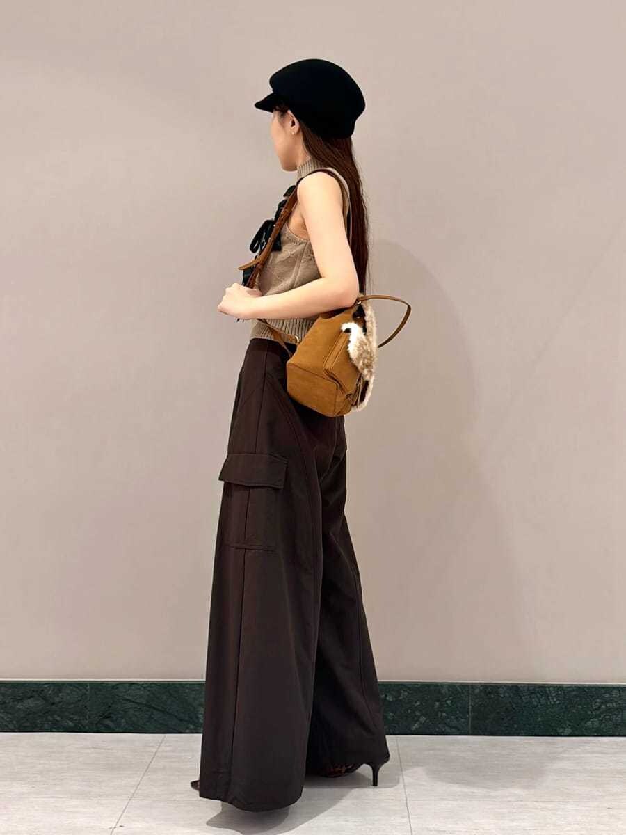 ブラウン系のその他パンツ、ベージュ系のニット/セーター、その他のバックパック/リュックを着用したレディースの夏コーディネートの2枚目の写真
