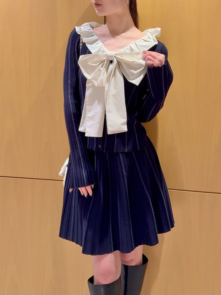 ブラック系のブーツ、ホワイト系のショルダーバッグ、ベージュ系のチェスターコートを着用したレディースの冬コーディネートの7枚目の写真