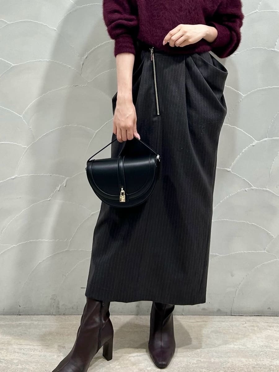 レッド系のニット/セーター、グレー系のスカート、ブラック系のハンドバッグを着用したレディースの秋コーディネートの4枚目の写真