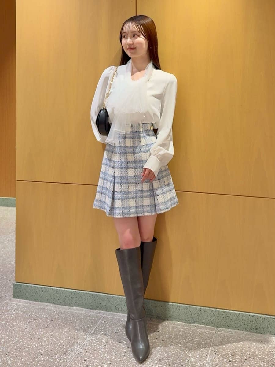 グレー系のブーツ、ブルー系のテーラードジャケット、ブルー系のスカートを着用したレディースの春コーディネートの4枚目の写真