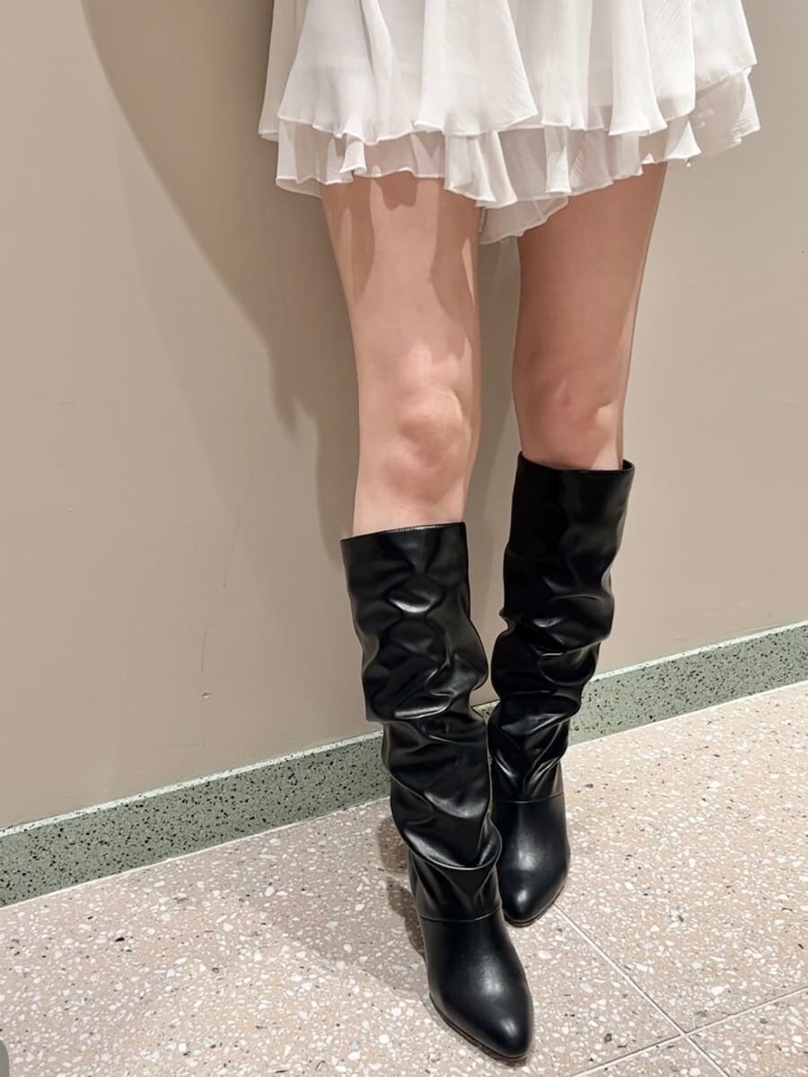 ブラック系のハンドバッグ、ブルー系のダウンジャケット/コート、ホワイト系のその他パンツを着用したレディースの秋コーディネートの8枚目の写真