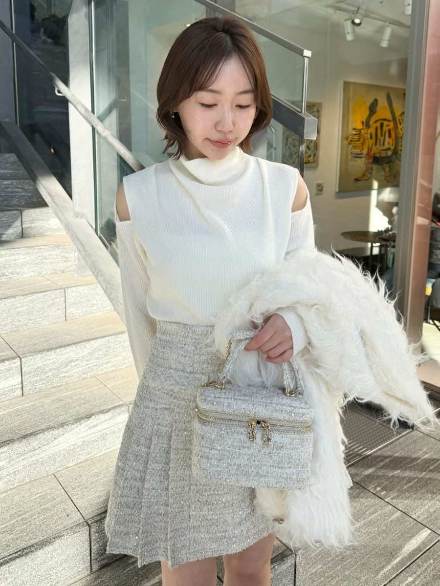 ホワイト系のスカート、ホワイト系のカーディガン/ボレロ、ホワイト系のハンドバッグを着用したレディースの冬コーディネートの3枚目の写真