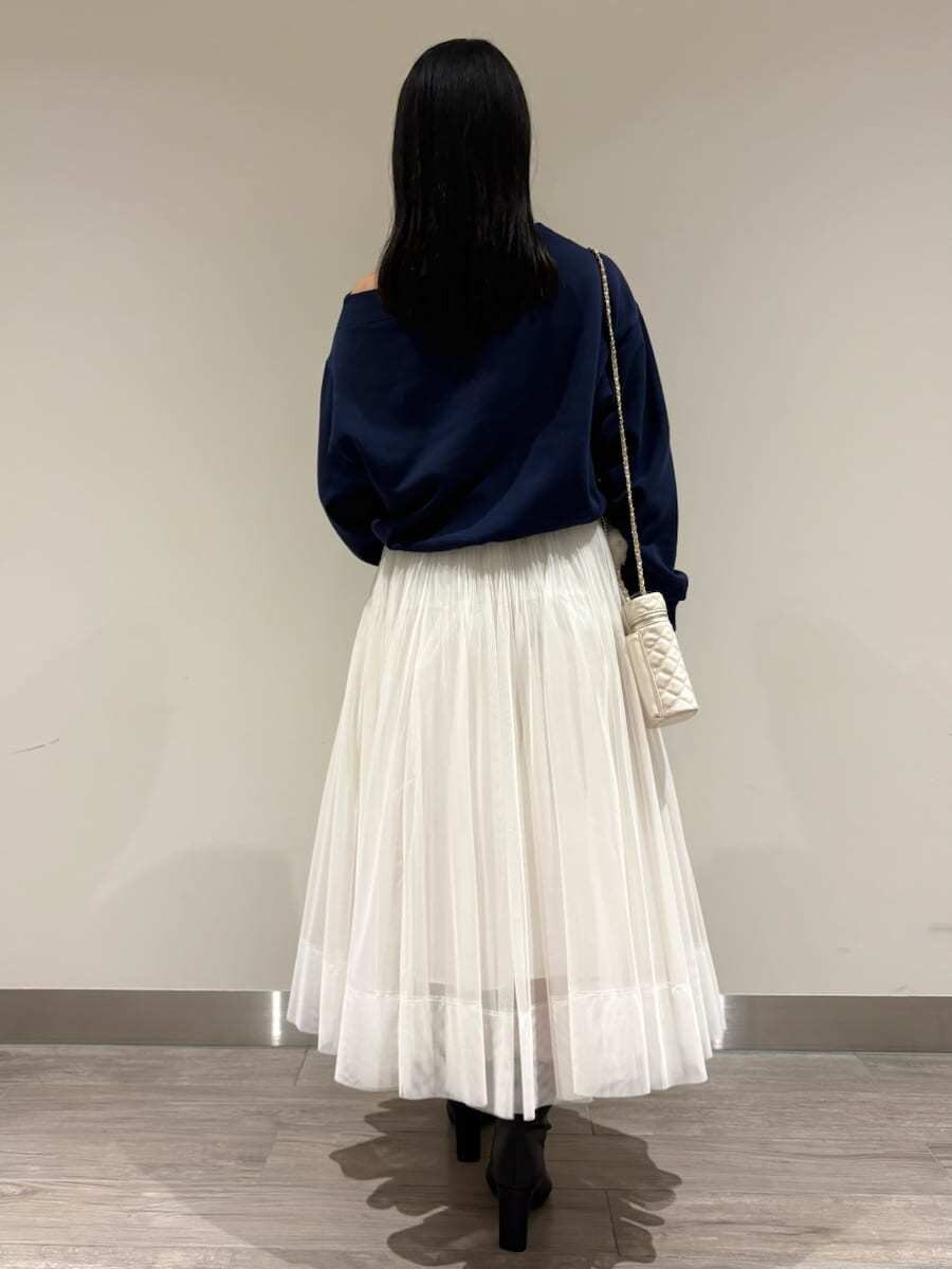 ブルー系のスウェット、ホワイト系のスカート、ブラック系のブーツを着用したレディースの秋コーディネートの3枚目の写真