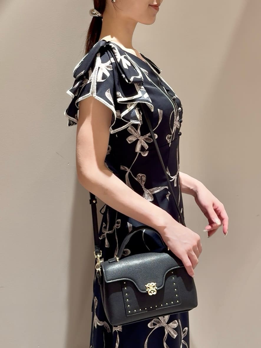 ブルー系のワンピース、ブラック系のブーツ、ブラック系のショルダーバッグを着用したレディースの秋コーディネートの6枚目の写真