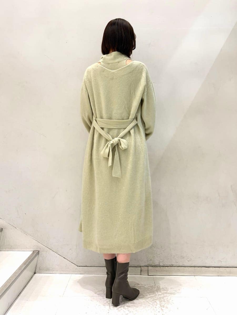 ベージュ系のキャミソール、グリーン系のチェスターコート、グリーン系のワンピースを着用したレディースの冬コーディネートの3枚目の写真