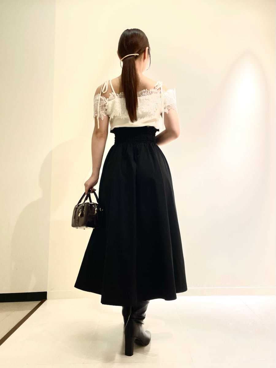 ホワイト系のニット/セーター、ブラック系のスカート、ブラウン系のボストンバッグを着用したレディースの秋コーディネートの4枚目の写真