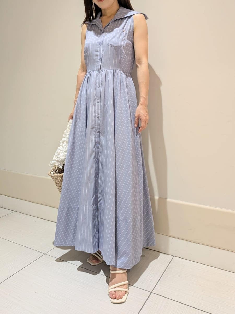 ブルー系のワンピース、ホワイト系のかごバッグ、ホワイト系のパンプスを着用したレディースの夏コーディネートの6枚目の写真