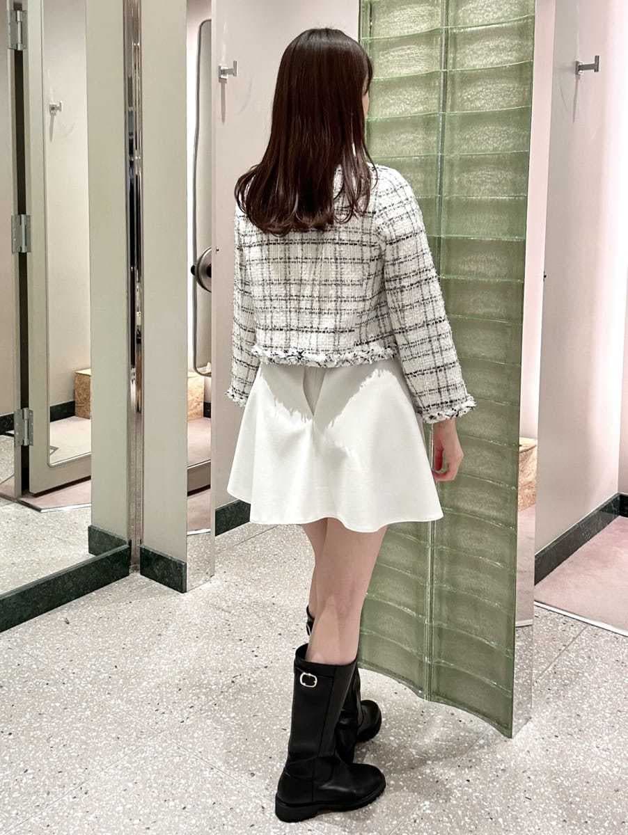 ホワイト系のノーカラージャケット、ホワイト系のその他パンツ、ブラック系のショルダーバッグを着用したレディースの冬コーディネートの4枚目の写真