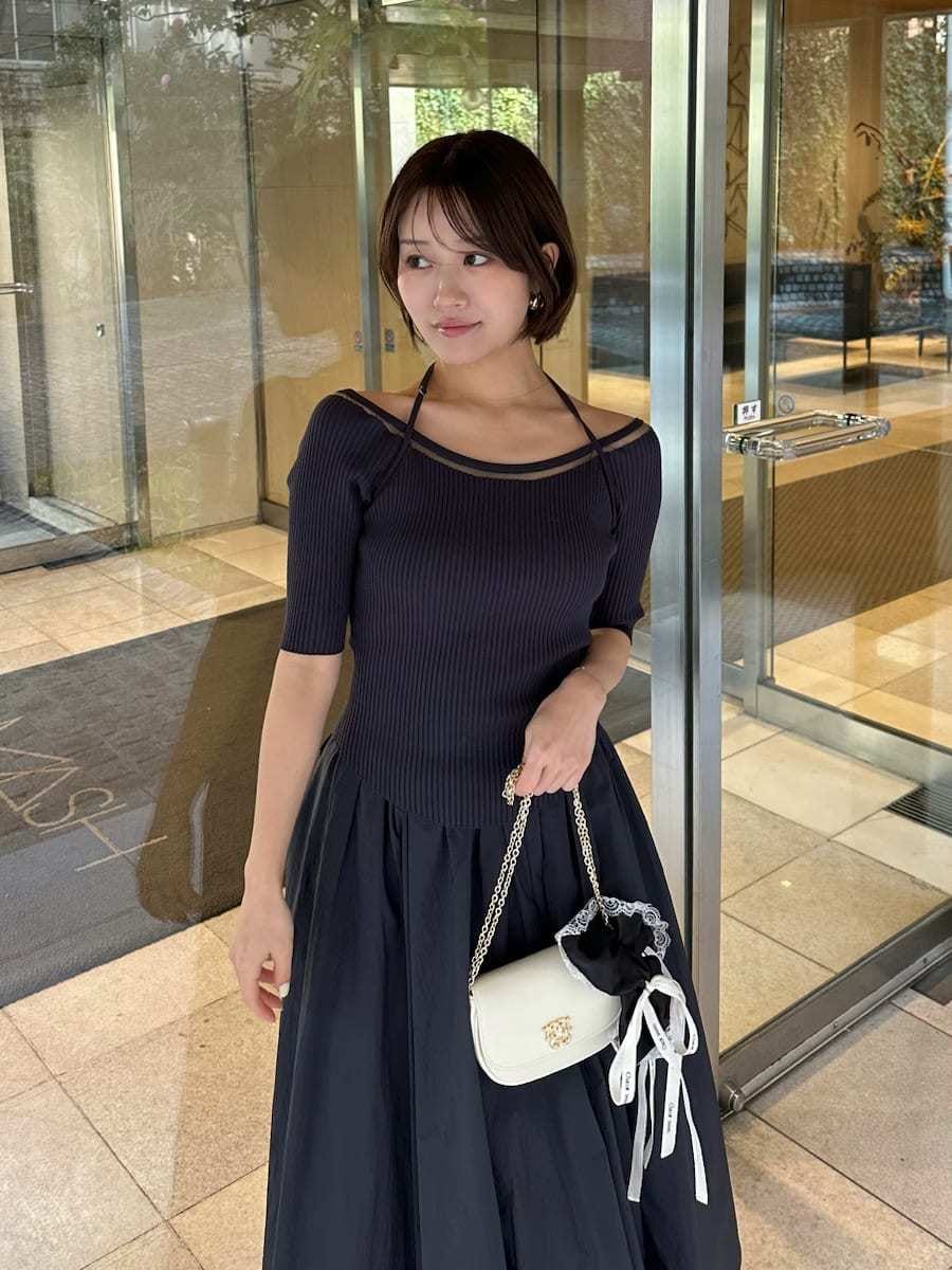 ホワイト系のショルダーバッグ、ブラック系のシュシュを着用したレディースの春コーディネートの3枚目の写真