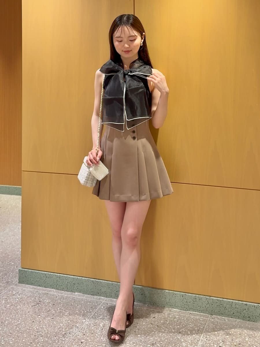 ブラウン系のその他パンツ、ホワイト系のスマホグッズを着用したレディースの春コーディネートの2枚目の写真