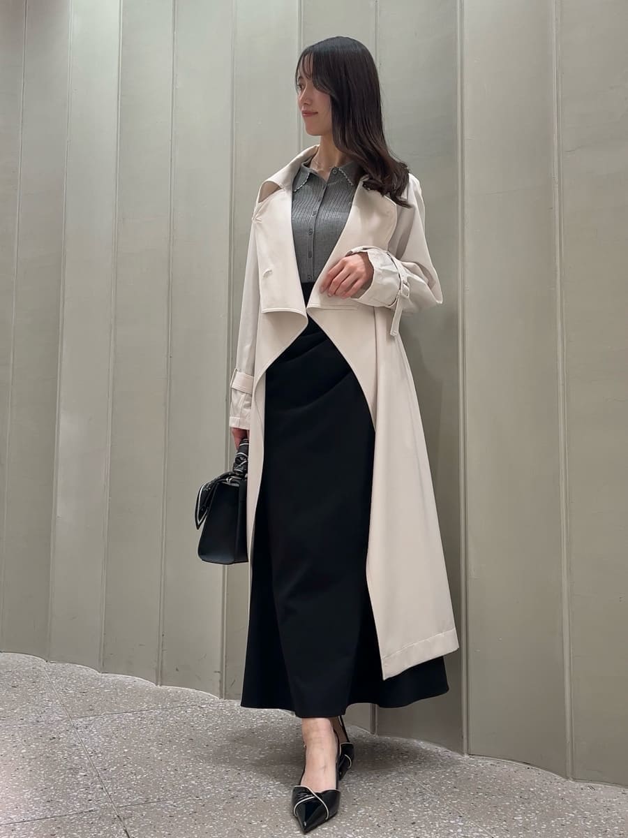 ホワイト系のトレンチコート、ブラック系のスカート、ブラック系のパンプスを着用したレディースの冬コーディネートの3枚目の写真
